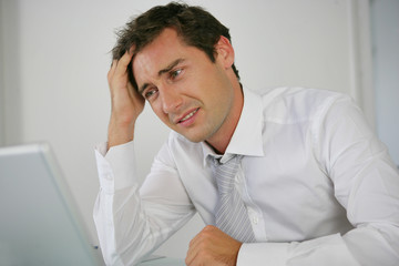 Naklejka premium Portrait d'un homme stressé devant un ordinateur portable