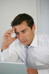 Portrait d'un homme anxieux devant un ordinateur portable