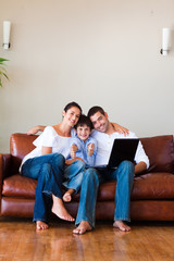 Family using a laptop with thumbs up and copy-space