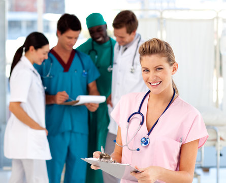 Blonde nurse with her team in the background