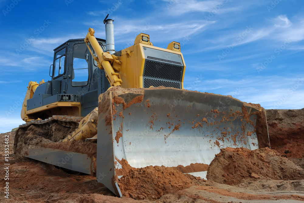 Poster Close-up view of heavy bulldozer standing in sandpit