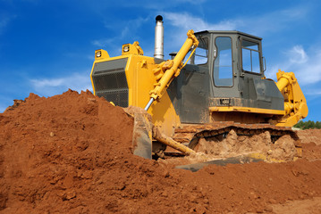Close view of heavy bulldozer moving sand in sandpit © Kadmy