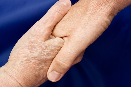 Close up of a hand shake against a blue background