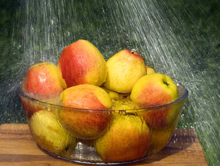 Apples in a glass bowl and rain drops