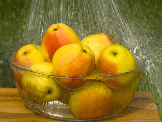 Apples in glass bowl and rain drops