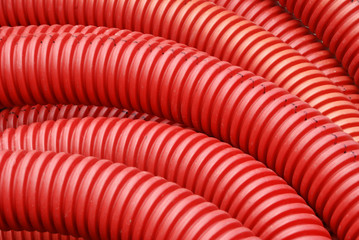 Coil of red plastic corrugated plumbing pipe in close up