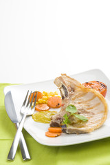 tasty pork chop with corn carrot tomato