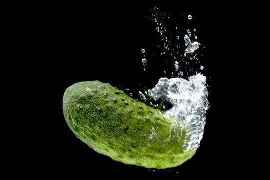 Cucumber in water on black