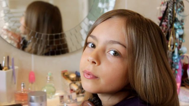fillette envoyant un bisou depuis sa coiffeuse