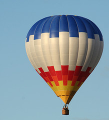air balloon in white, blue and yellow color on sky background in sunny day