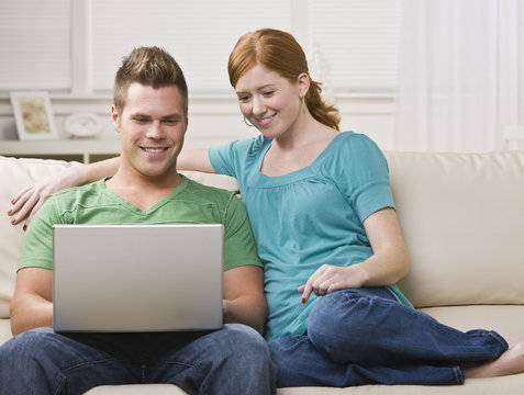 Couple Viewing Laptop Together on the Couch