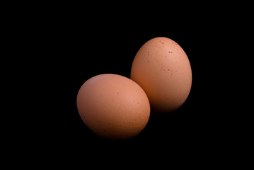 Two eggs isolated on black
