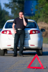 Car accident on a road. Focus is on the red triangle sign