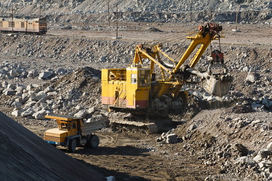 quarry excavator loads rock in dump truck