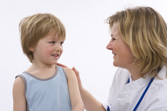 Female doctor is talking to a little boy