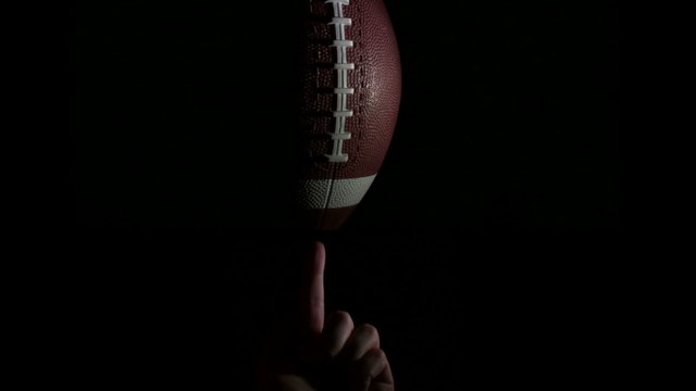 Football spins on finger against black - HD