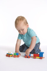 Toddler boy playing with a wooden toy train