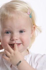 Portrait of a timid toddler girlwith her finger in her mouth