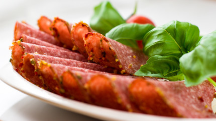 Sliced salami with basil