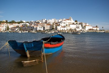 Fototapeta na wymiar Fishing boat with Ferragudo village in the background.