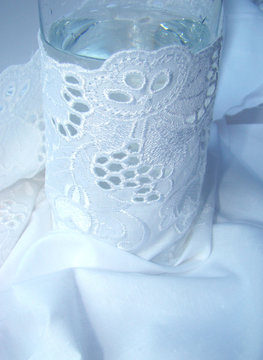 glass with water is turned in white fabric with a lace