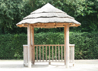 Naklejka premium A Thatched Roof Outdoors Children's Play Shelter.