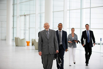 Hommes et femmes d'affaires marchant dans une société moderne