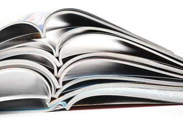 pile of colorful opened magazines on white background