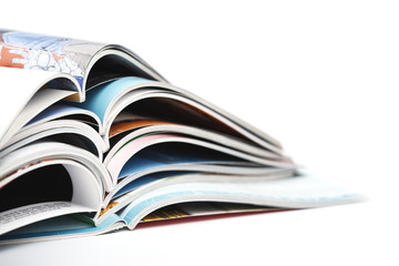 pile of colorful opened magazines on white background