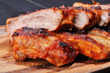 Grilled pork ribs on wooden plate