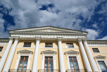 Obraz premium The ancient house against the blue sky with clouds