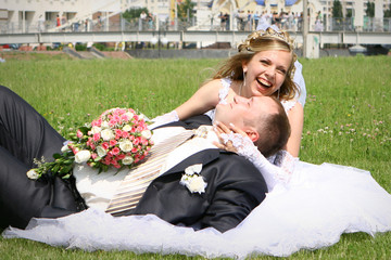 Groom laying on bridal dress