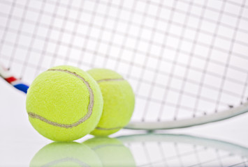 Tennis balls and racket on white background