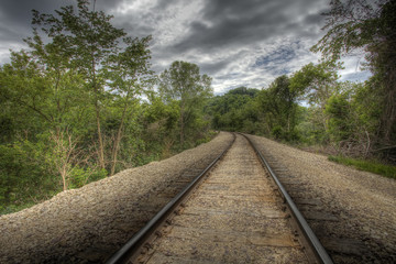 HDR image of railroad tracks through forest