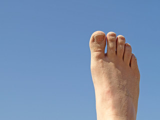 Fu&szlig; am Strand vor blauem Himmel
