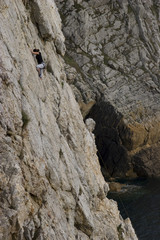 young woman climbing a high rock
