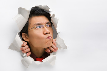 Man from hole in wall contemplate looking his blank left side