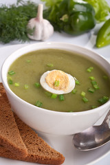 serving of spinach cream soup with vegetables at the back