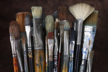 Close up of artist paint brushes with dark textured background