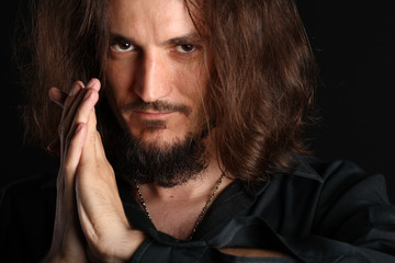 Young man praying isolated on black background