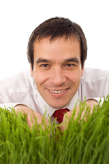 Naklejka na ściany i meble Businessman hiding in grass - isolated