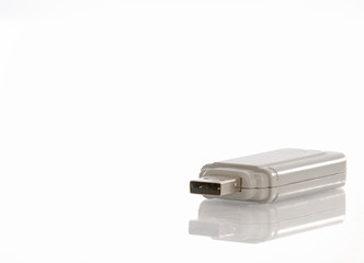 Usb flash memory drive with reflection on white background.