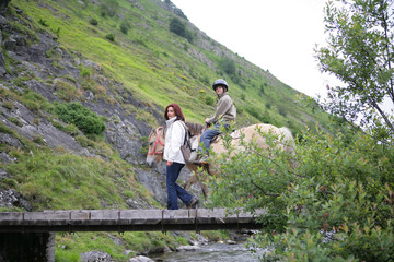 Femme marchant sur un pont près d'une enfant sur un poney