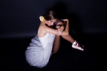 Ballerina in white tutu on black background