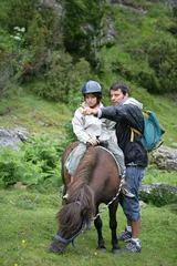 Foto op Canvas garçon assis sur un poney près d'un homme pointant du doigt © auremar