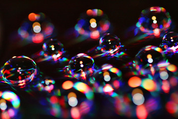 Water drops over a DVD become colorful bubbles
