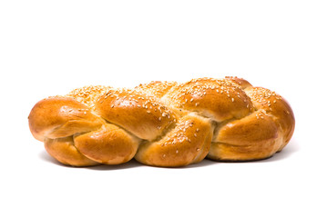 Single fresh bun and ear of wheat, soft shadow on white