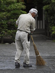 Barrendero trabajando en santuario sintoista en Japon