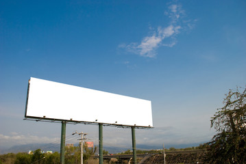 Big white blank billboard with blue sky and mountain backdrop