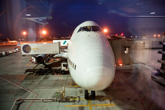 Flugzeug am Gate bei Nacht von aussen wird beladen